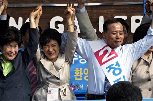 13일 오후 경기도 광주 국회의원 재선거 한나라당 정진섭(오른쪽) 후보 지원에 나선  박근혜 대표가 손을 들어 지지자들의 환호에 답하고 있다. 